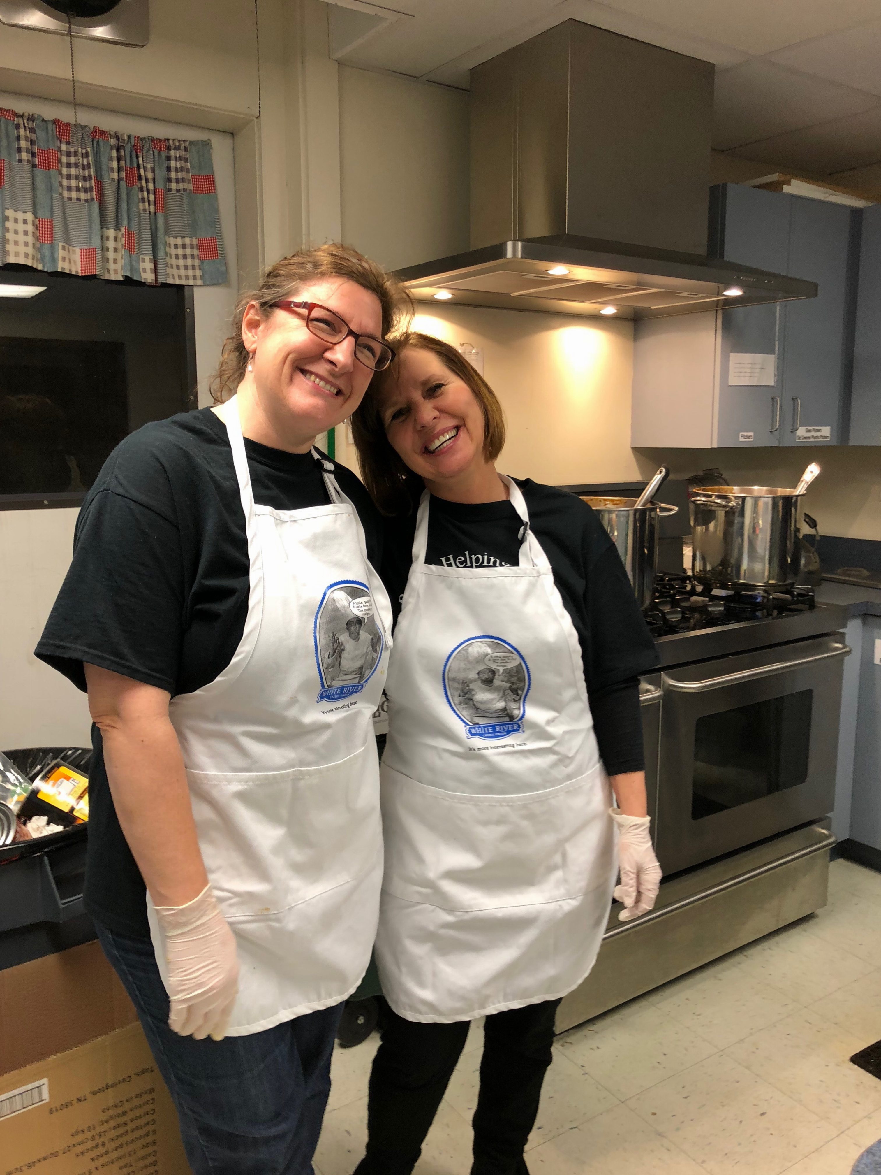two women in aprons in a kitchen