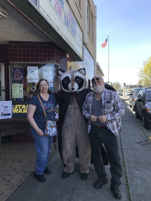 Rocky Raccoon posing with man and woman outside Chalet Theater