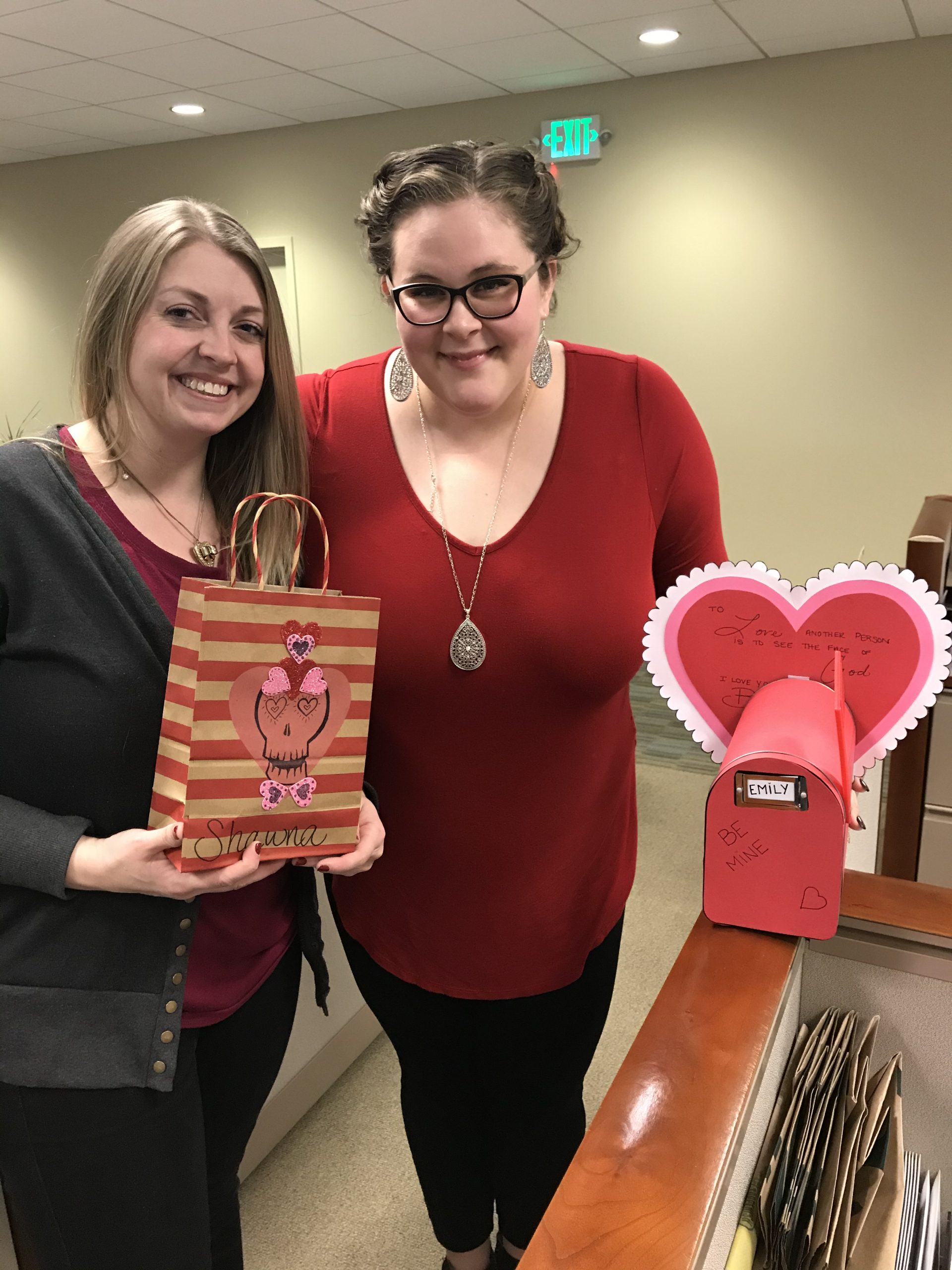 Two WRCU staff holding hearts