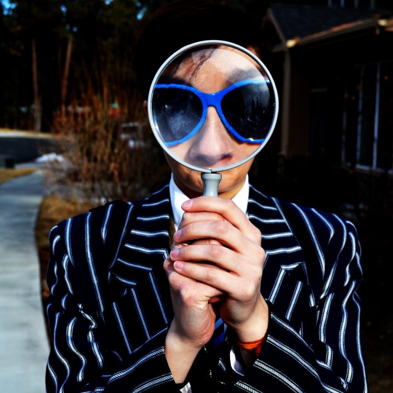 person looking thru magnifying glass
