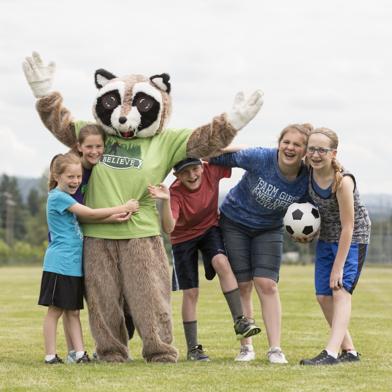 Rocky Raccoon mascot with kids on soccer field