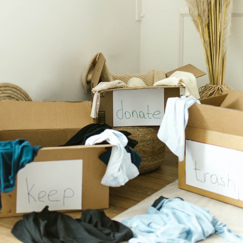 cardboard boxes of keep, donate, trash items for winter decluttering