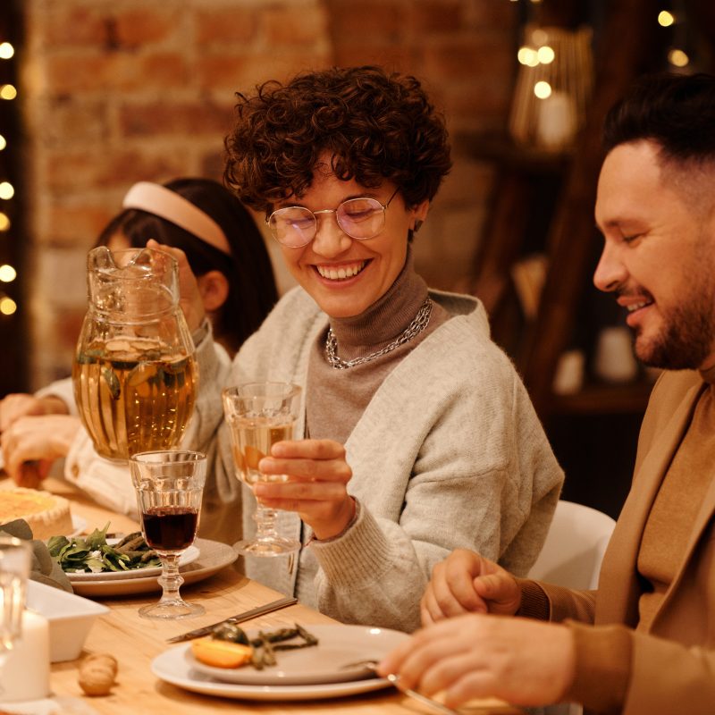 Organize your finances in the new year with WRCU. The picture is of a group having a group meal and saying cheers to the new year.