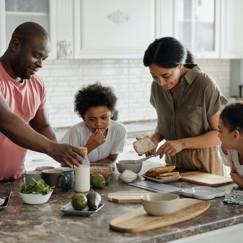A family gathered around a kitchen island discussing insured deposits and eating