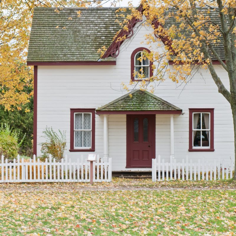 The exterior of a small house with a white picket fence on a blog about mortgage loan changes