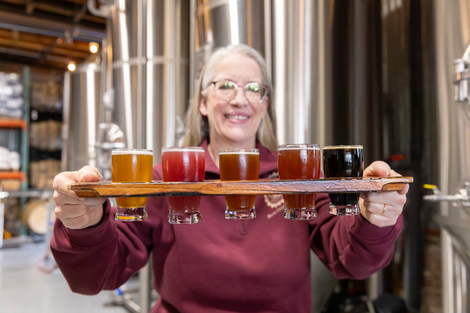 A small business owner holding up a flight of beer on a blog about small business banking tips