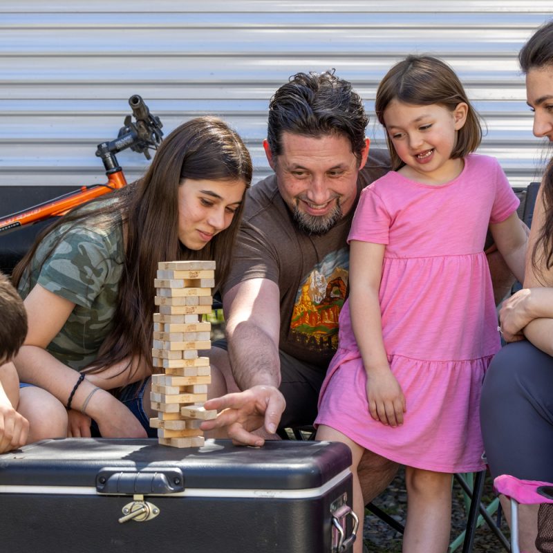 A family playing jenga on a blog about cutting newborn expenses
