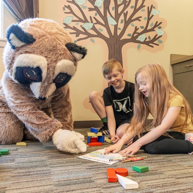 Kids playing with their favorite mascot Rocky the Raccoon on a blog about back to school loan enumclaw