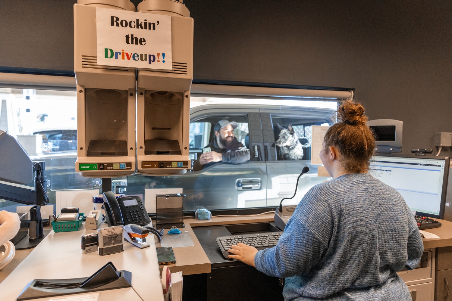 a bank teller helping a member at the credit union on international credit union day