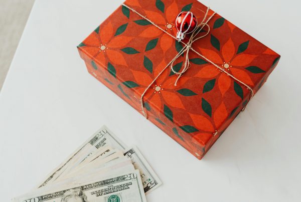 A wrapped present and cash on a blog about holiday budget