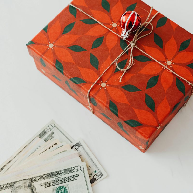 A wrapped present and cash on a blog about holiday budget
