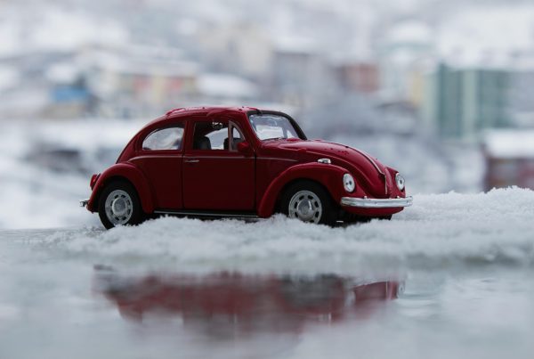 A toy car on a pile of snow on a blog about auto loan refinance
