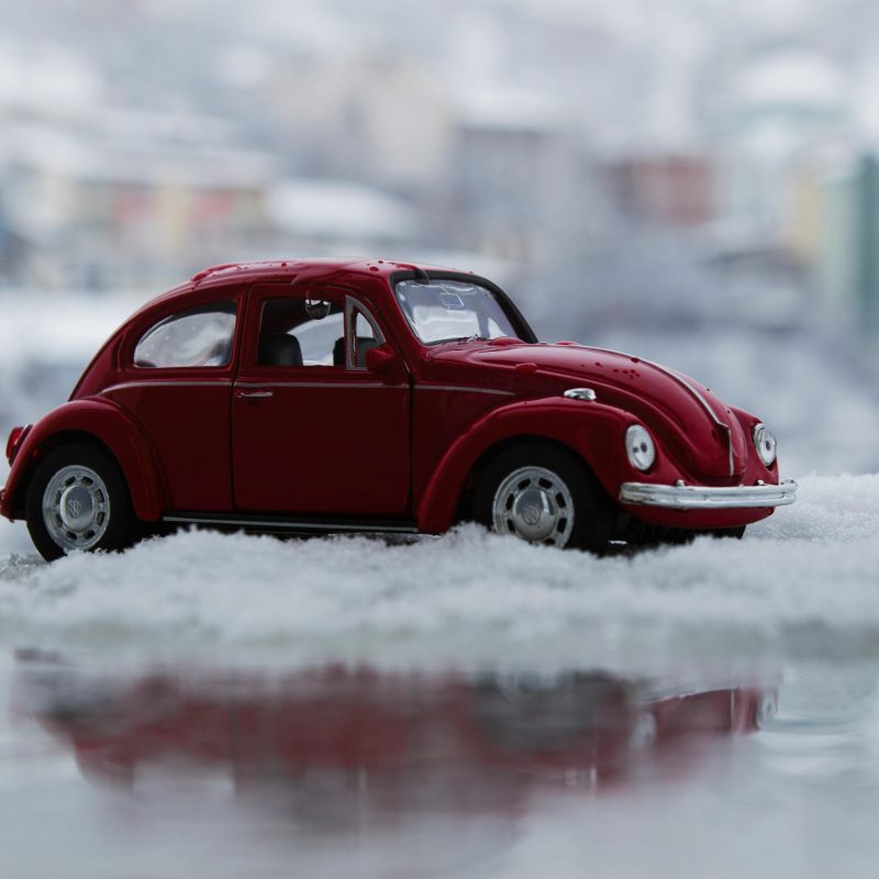 A toy car on a pile of snow on a blog about auto loan refinance