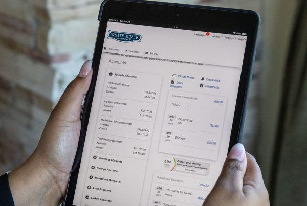 Photo of a person holding an ipad with a online banking security feature