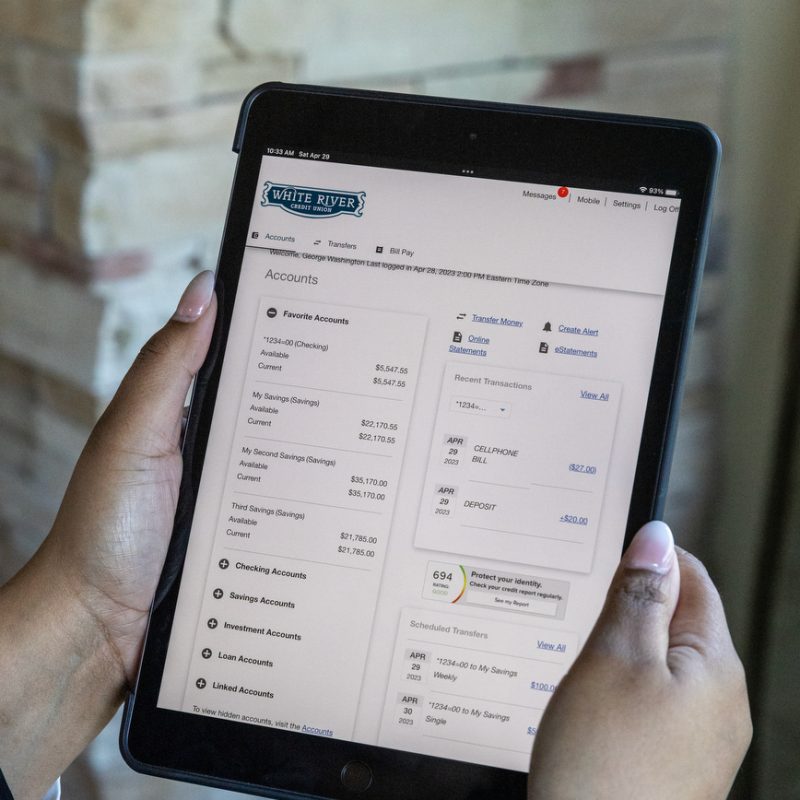 Photo of a person holding an ipad with a online banking security feature